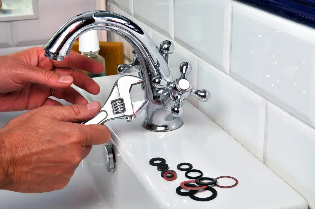 Plumber performing maintenance on a bathroom faucet in Wildomar
