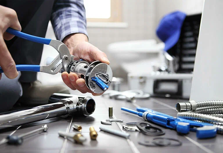 Technician repairing a plumbing fixture with professional tools in Wildomar