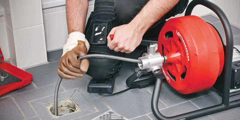Plumber using a drain-cleaning machine in Wildomar
