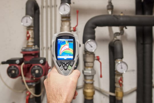 Plumber using a thermal imaging camera to inspect pipes in Wildomar