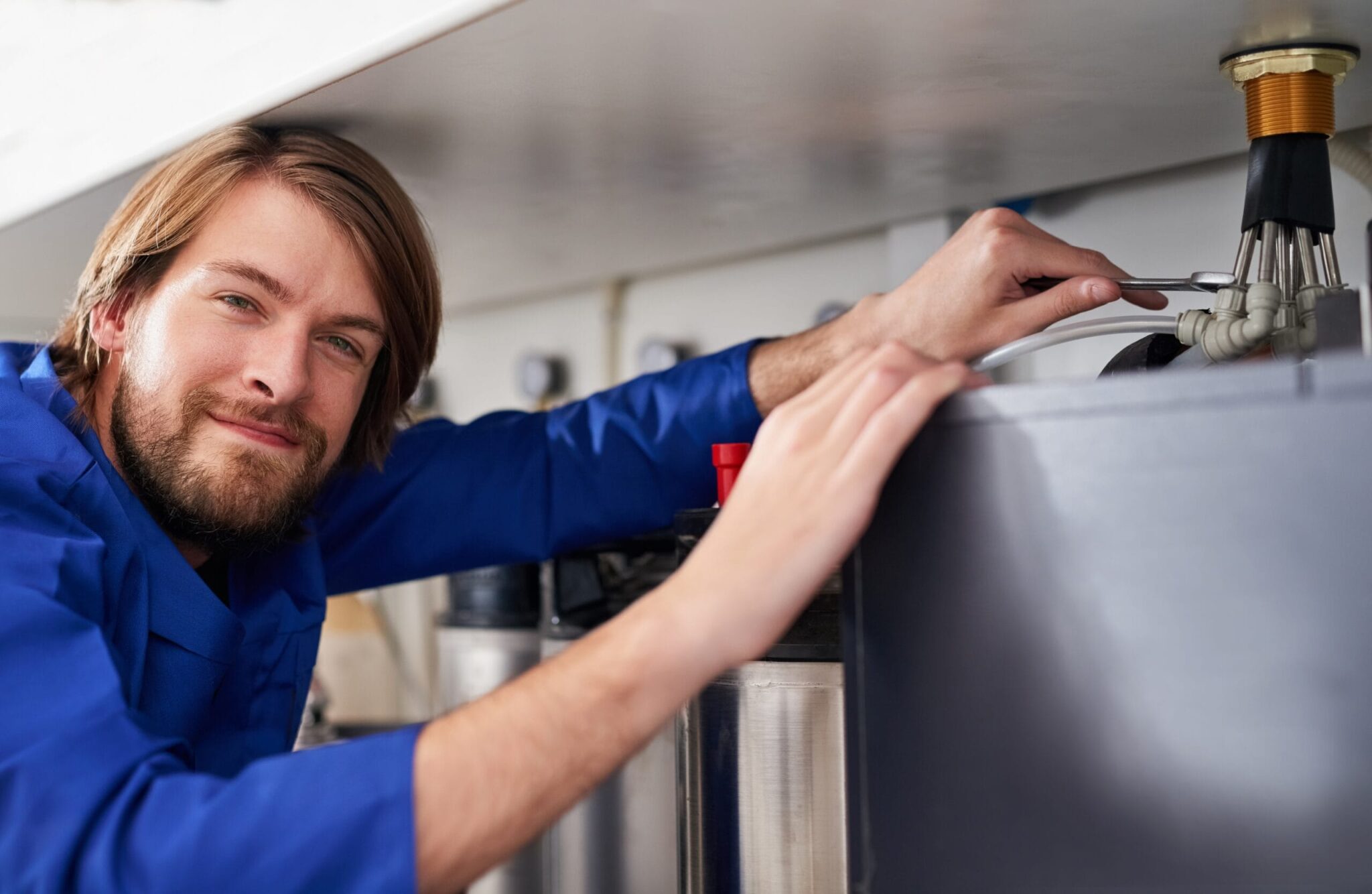 Technician servicing a residential water heater tank in Wildomar